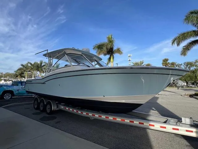 Slide: The Image of 2019 Grady-White Freedom 325 boat on trailer, palm trees in background. - 23