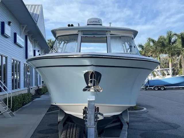 Slide: The Image of 2019 Grady-White Freedom 325 boat on trailer, parked near building and palm trees. - 3