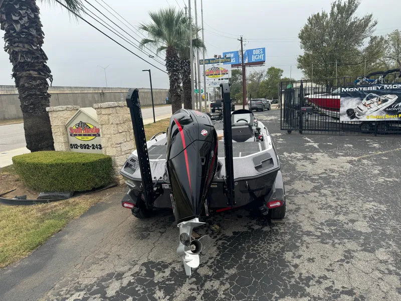 Slide: The Image of 2025 Vexus VXS21 boat parked outdoors near palm trees and signage. - 2
