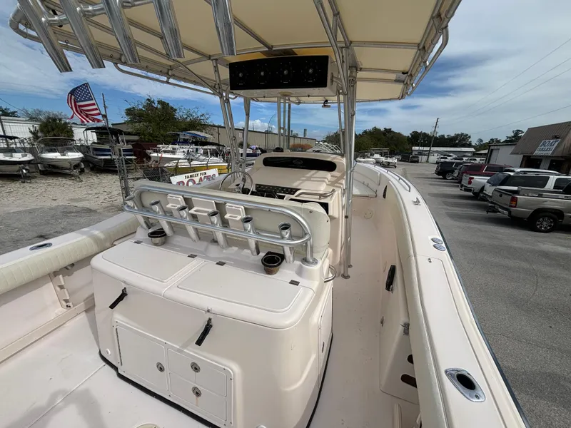 Slide: The Image of 2005 Grady-White Bimini 306 boat interior with seating and console, parked outdoors. - 18
