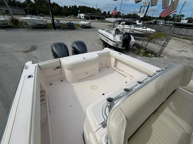 Slide: The Image of 2005 Grady-White Bimini 306 boat interior with dual engines, docked in a marina. - 30