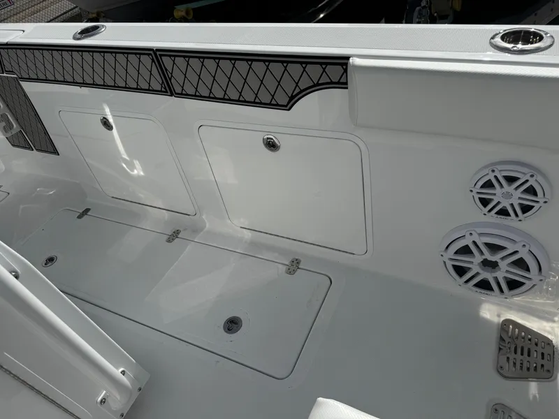 Slide: The Image of 2025 Wellcraft 302 Fisherman boat deck with storage compartments and speakers. - 13