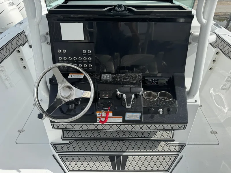 Slide: The Image of 2025 Wellcraft 302 Fisherman boat dashboard with steering wheel and controls. - 15