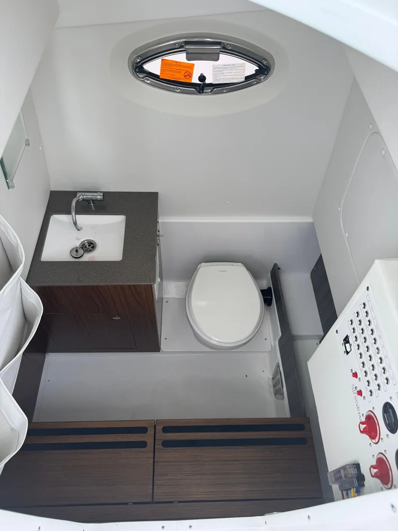 Slide: The Image of 2025 Wellcraft 302 Fisherman boat interior with sink, toilet, and control panel. - 28