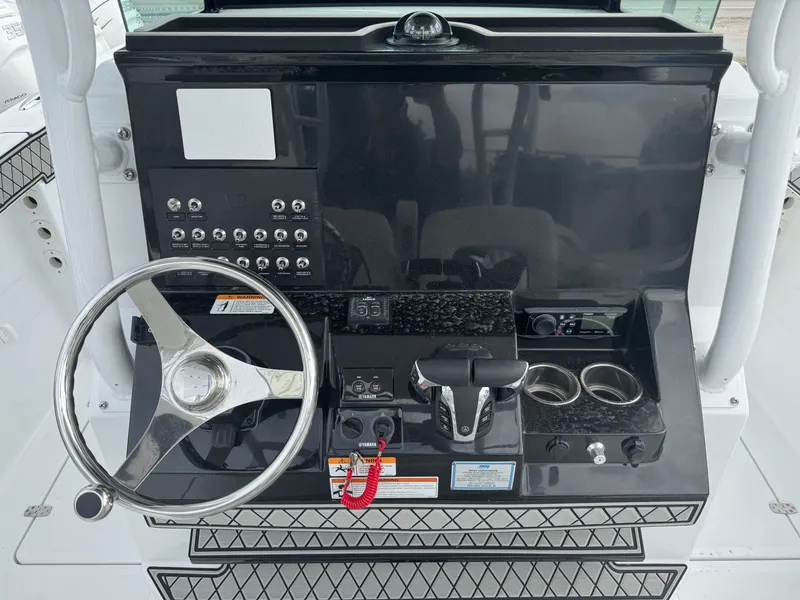 Slide: The Image of 2025 Wellcraft 302 Fisherman boat dashboard with steering wheel and control panel. - 31