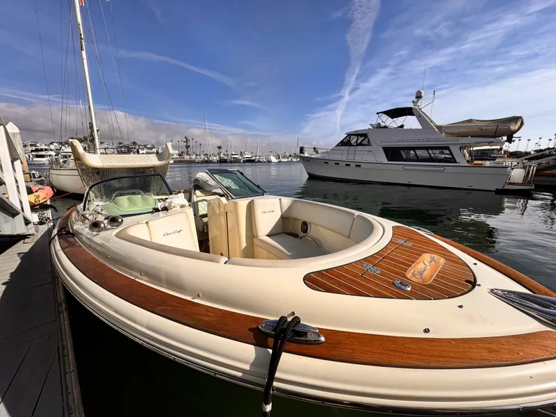 Slide: The Image of 2014 Chris-Craft Launch 25 boat docked in a marina under a clear blue sky. - 2