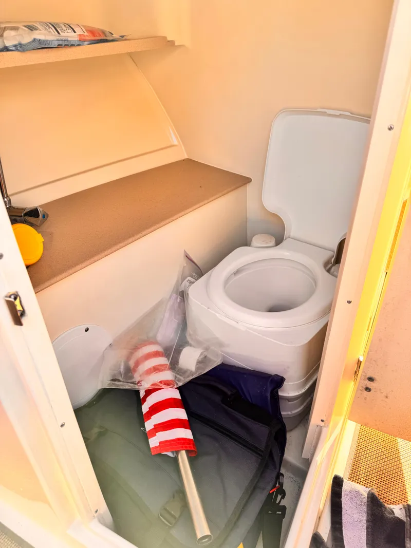 Slide: The Image of 2014 Chris-Craft Launch 25 boat interior with compact toilet and storage area. - 7