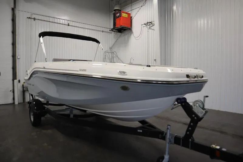 Slide: The Image of 2024 Bayliner 2050 DX boat in a showroom, on a trailer. - 3