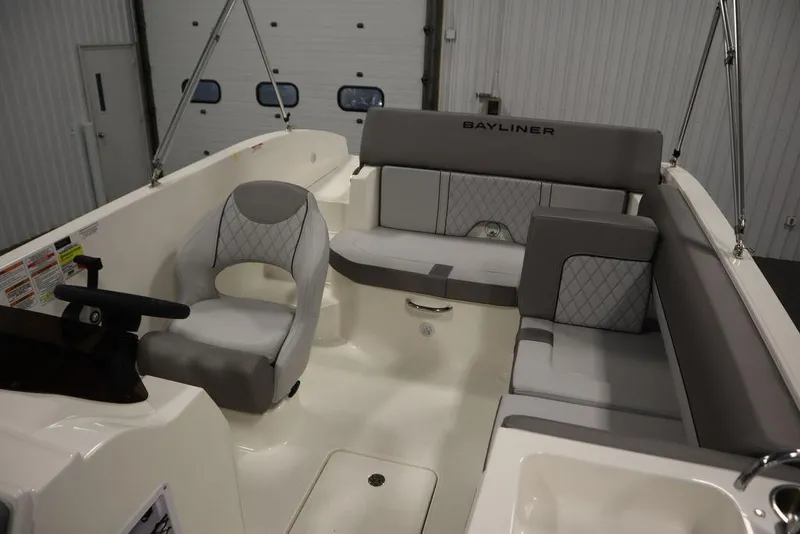Slide: The Image of 2024 Bayliner 2050 DX boat interior with gray seating and steering console. - 37