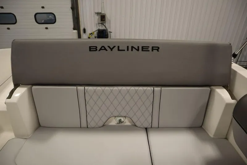 Slide: The Image of 2024 Bayliner 2050 DX boat interior seating with logo, featuring gray upholstery. - 45