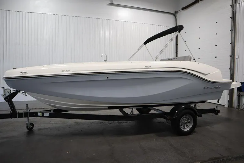 Slide: The Image of 2024 Bayliner 2050 DX boat on trailer in indoor showroom. - 8