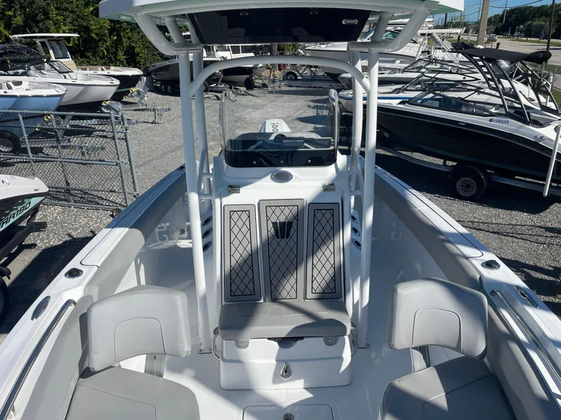 Slide: The Image of 2023 Wellcraft 222 Fisherman boat with spacious seating and modern design in a marina setting. - 20