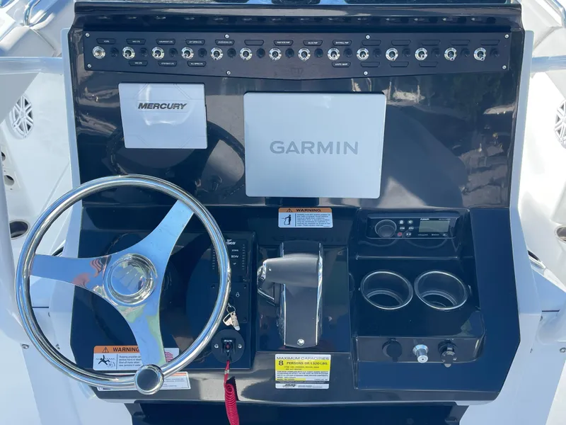 Slide: The Image of 2023 Wellcraft 222 Fisherman dashboard with Garmin and Mercury controls. - 6
