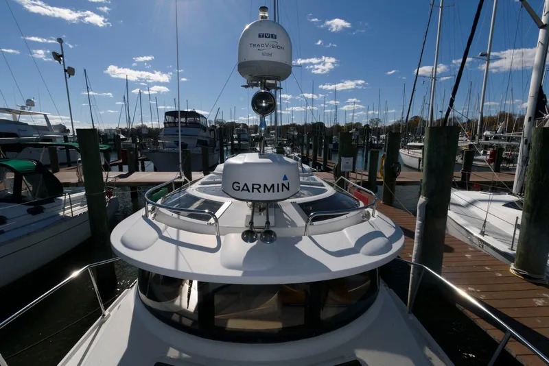 Slide: The Image of 2015 Ranger Tugs R-29S docked, featuring Garmin navigation equipment under a clear blue sky. - 15