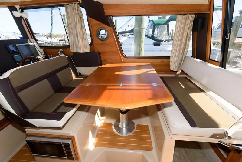 Slide: The Image of Interior of 2015 Ranger Tugs R-29S with wooden table and seating. - 18
