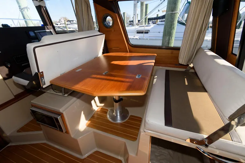 Slide: The Image of Interior of 2015 Ranger Tugs R-29S with wooden table and seating area. - 19