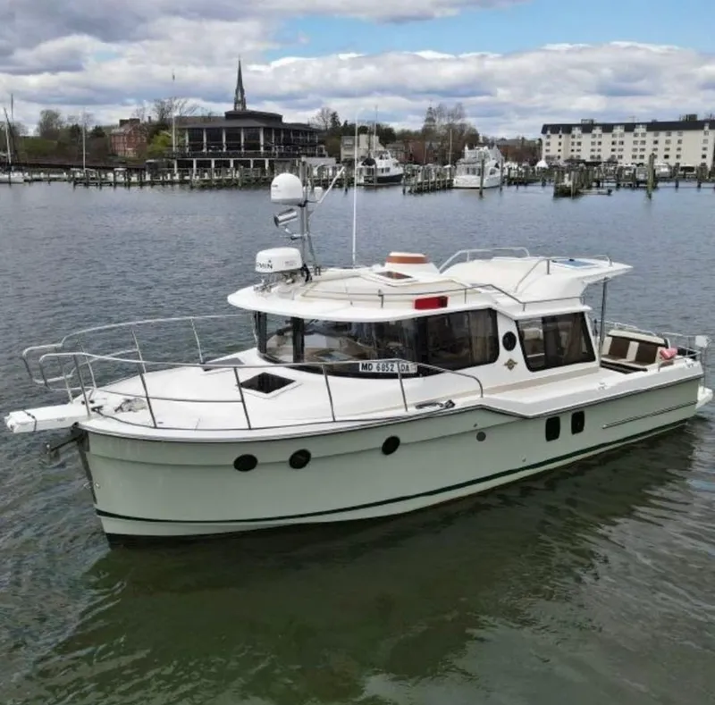 Slide: The Image of 2015 Ranger Tugs R-29S boat on calm water near a marina. - 2
