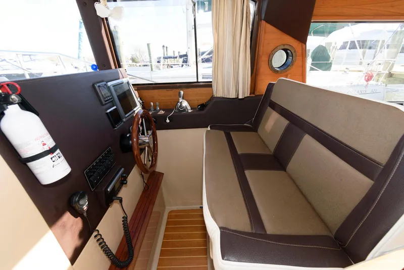 Slide: The Image of Interior of 2015 Ranger Tugs R-29S boat with steering wheel and seating area. - 21