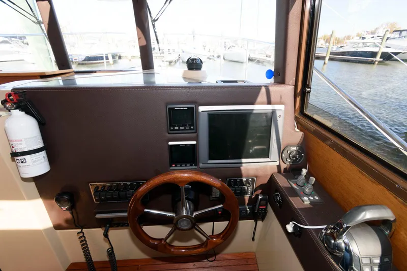 Slide: The Image of 2015 Ranger Tugs R-29S helm with steering wheel and navigation controls. - 22