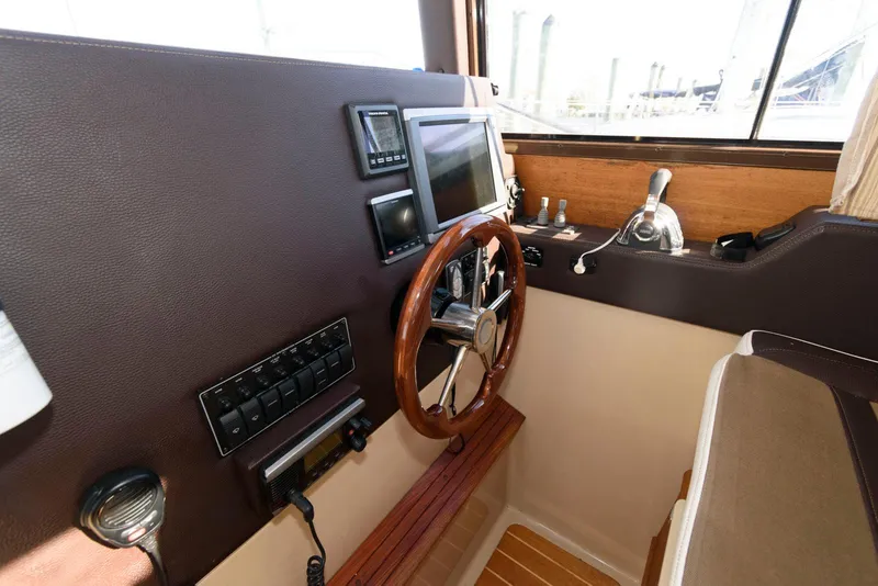 Slide: The Image of Interior helm of 2015 Ranger Tugs R-29S with wooden steering wheel and navigation controls. - 23