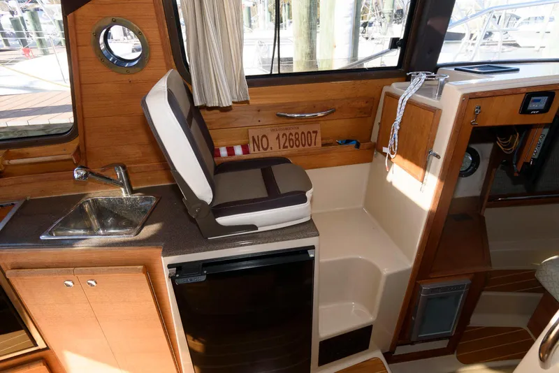 Slide: The Image of 2015 Ranger Tugs R-29S interior with sink, seating, and storage. - 25