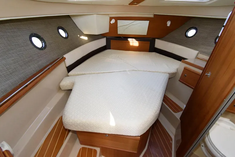 Slide: The Image of 2015 Ranger Tugs R-29S cabin interior with cozy bed and wooden accents. - 26