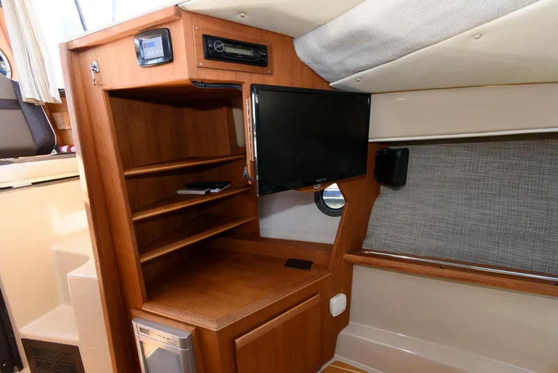 Slide: The Image of Interior of 2015 Ranger Tugs R-29S with wooden shelves and mounted TV. - 28