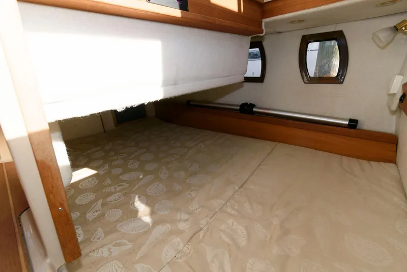 Slide: The Image of 2015 Ranger Tugs R-29S cabin interior with cozy bed and porthole windows. - 29