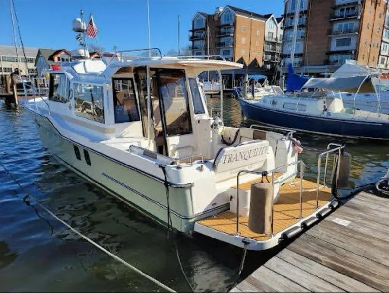 Slide: The Image of 2015 Ranger Tugs R-29S boat docked in marina, surrounded by other vessels. - 3