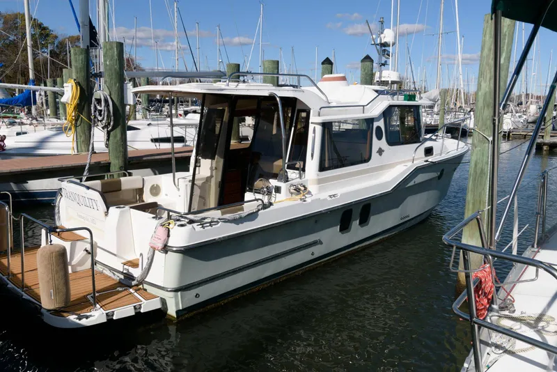 Slide: The Image of 2015 Ranger Tugs R-29S docked in a marina, surrounded by sailboats. - 4