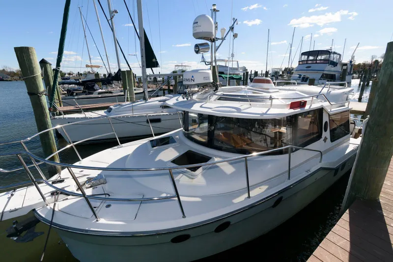 Slide: The Image of 2015 Ranger Tugs R-29S docked at marina, surrounded by other boats. - 5