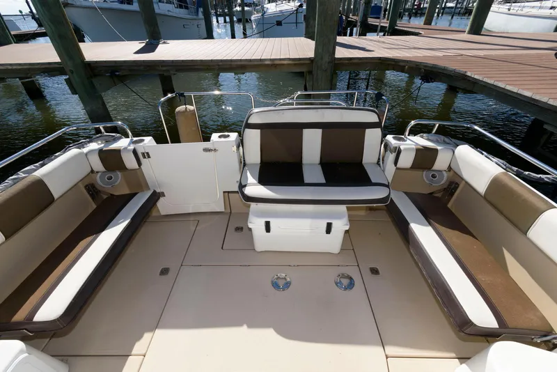 Slide: The Image of 2015 Ranger Tugs R-29S boat interior with cushioned seating and dock view. - 6