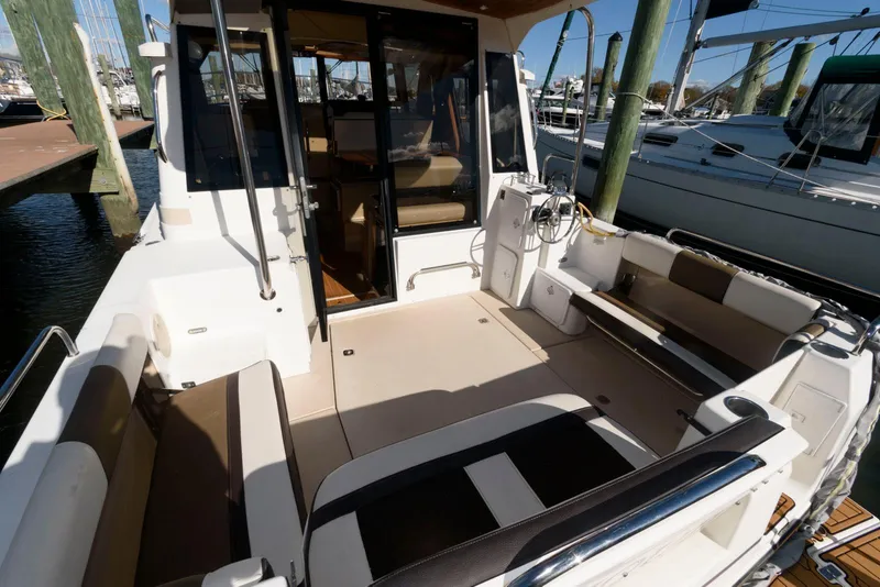 Slide: The Image of 2015 Ranger Tugs R-29S boat interior with seating and dock view. - 8