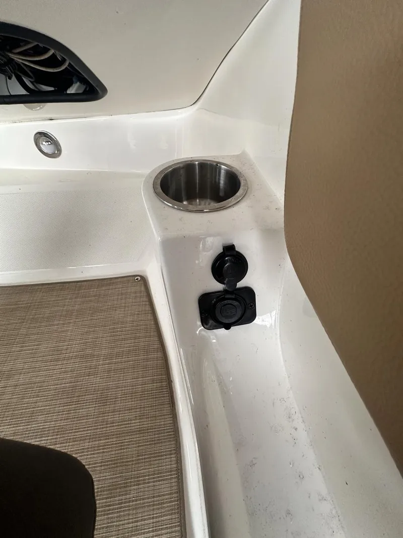Slide: The Image of 2019 Sea Ray SPX 230 OB boat interior with cup holder and power outlets. - 14