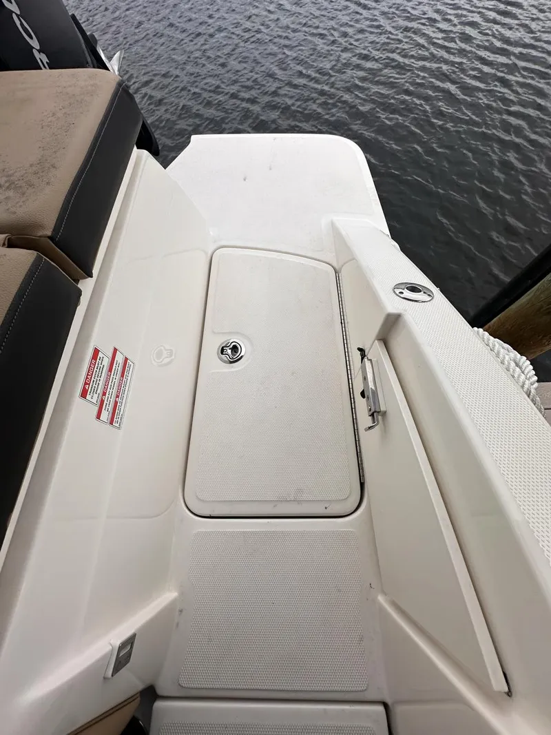 Slide: The Image of 2019 Sea Ray SPX 230 OB boat deck with storage compartment, near water. - 22