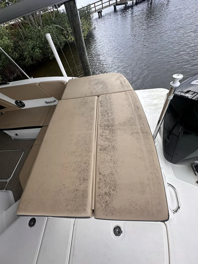 Slide: The Image of 2019 Sea Ray SPX 230 OB boat with beige seating, docked by the water. - 28