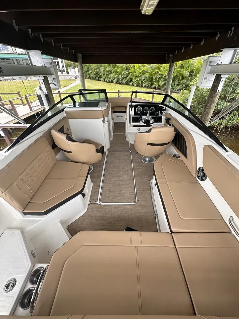 Slide: The Image of 2019 Sea Ray SPX 230 OB boat interior with tan seating and modern dashboard. - 3