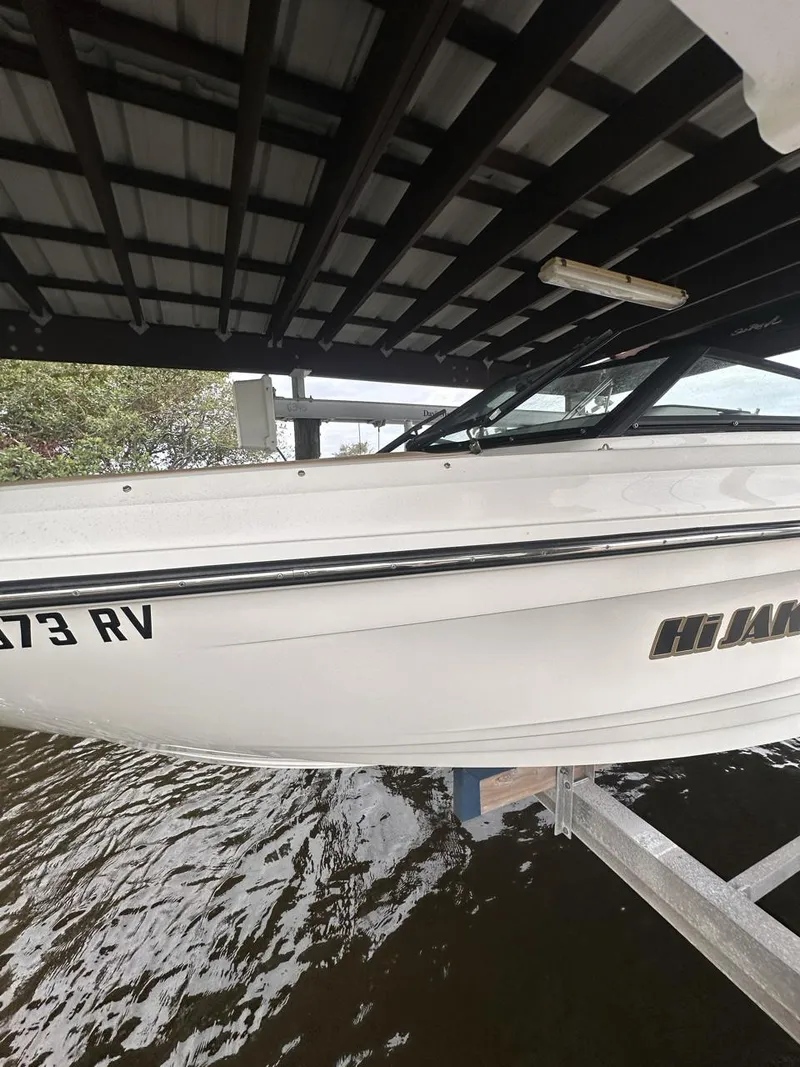 Slide: The Image of 2019 Sea Ray SPX 230 OB boat docked under a covered structure. - 46