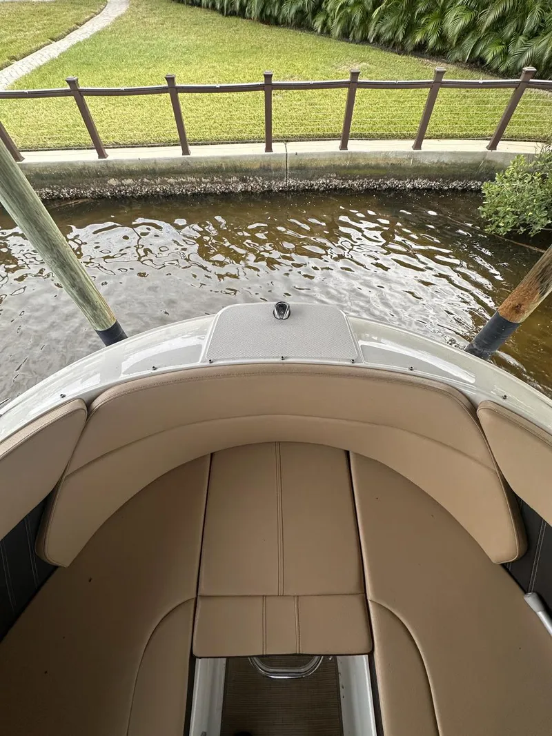 Slide: The Image of 2019 Sea Ray SPX 230 OB boat with tan seating, docked by a grassy area. - 5