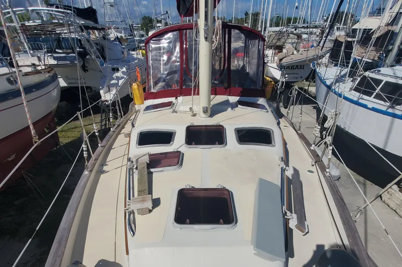 Slide: The Image of 1987 Irwin MKII sailboat deck view with hatches, docked among other boats. - 10