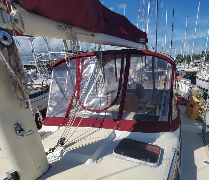 Slide: The Image of 1987 Irwin MKII sailboat with red canopy docked at marina. - 11