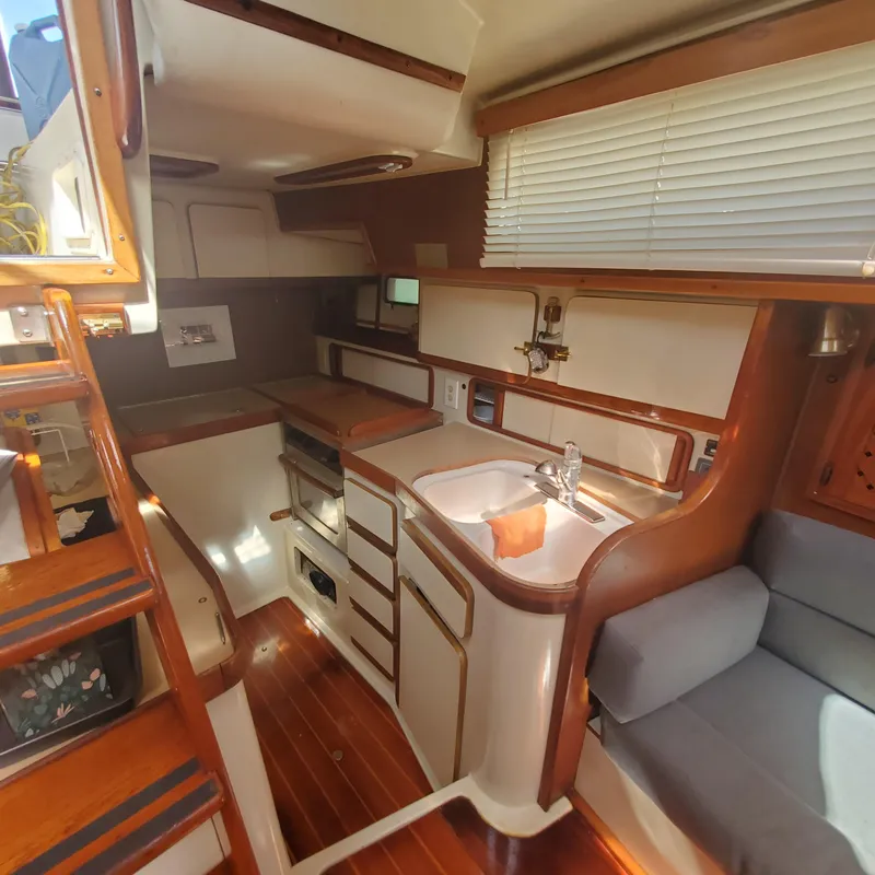 Slide: The Image of Interior of 1987 Irwin MKII sailboat with wooden cabinetry and compact kitchen area. - 15