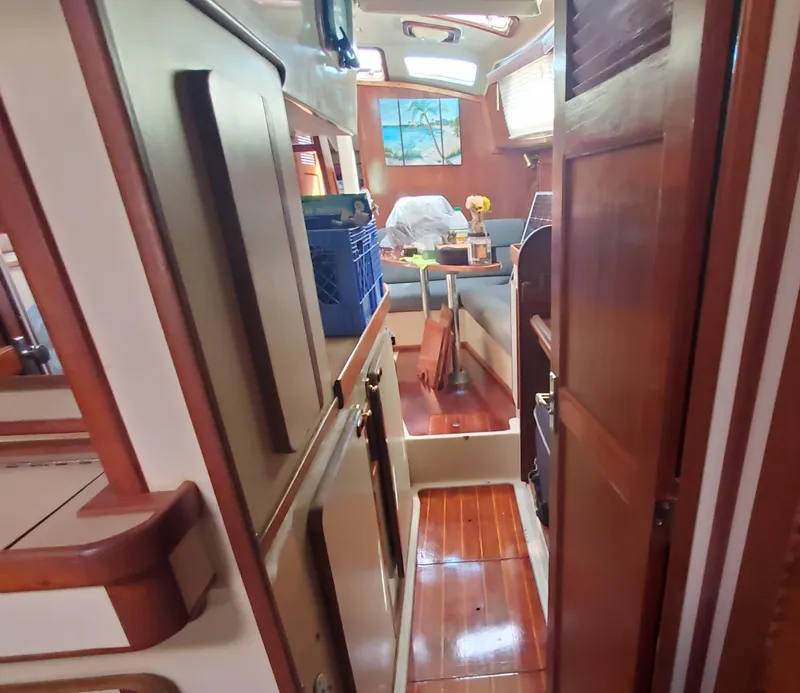 Slide: The Image of Interior of a 1987 Irwin MKII sailboat, featuring wooden cabinetry and a cozy dining area. - 24