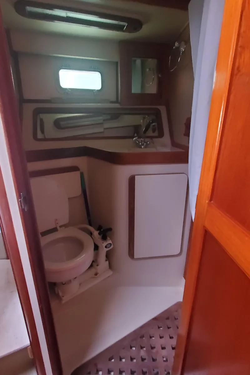 Slide: The Image of 1987 Irwin MKII boat bathroom with toilet, sink, and window. - 25