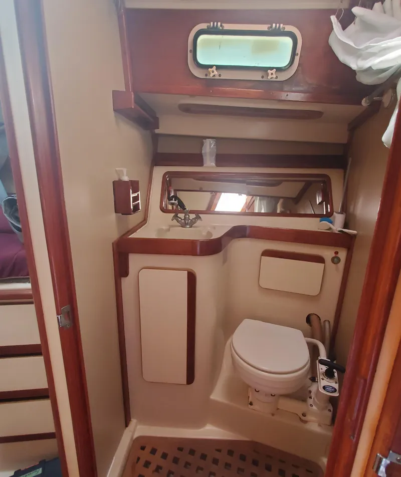 Slide: The Image of 1987 Irwin MKII yacht bathroom with compact design, wooden accents, and nautical window. - 27