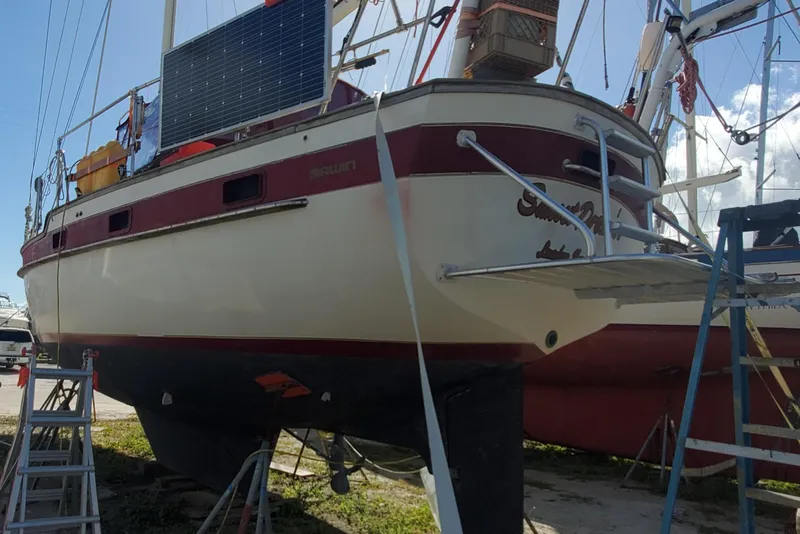 Slide: The Image of 1987 Irwin MKII sailboat on land, featuring solar panels and maintenance equipment. - 6