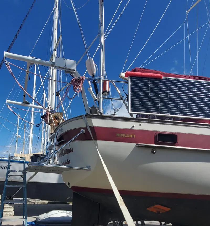 Slide: The Image of 1987 Irwin MKII sailboat with solar panel, docked under clear blue sky. - 7
