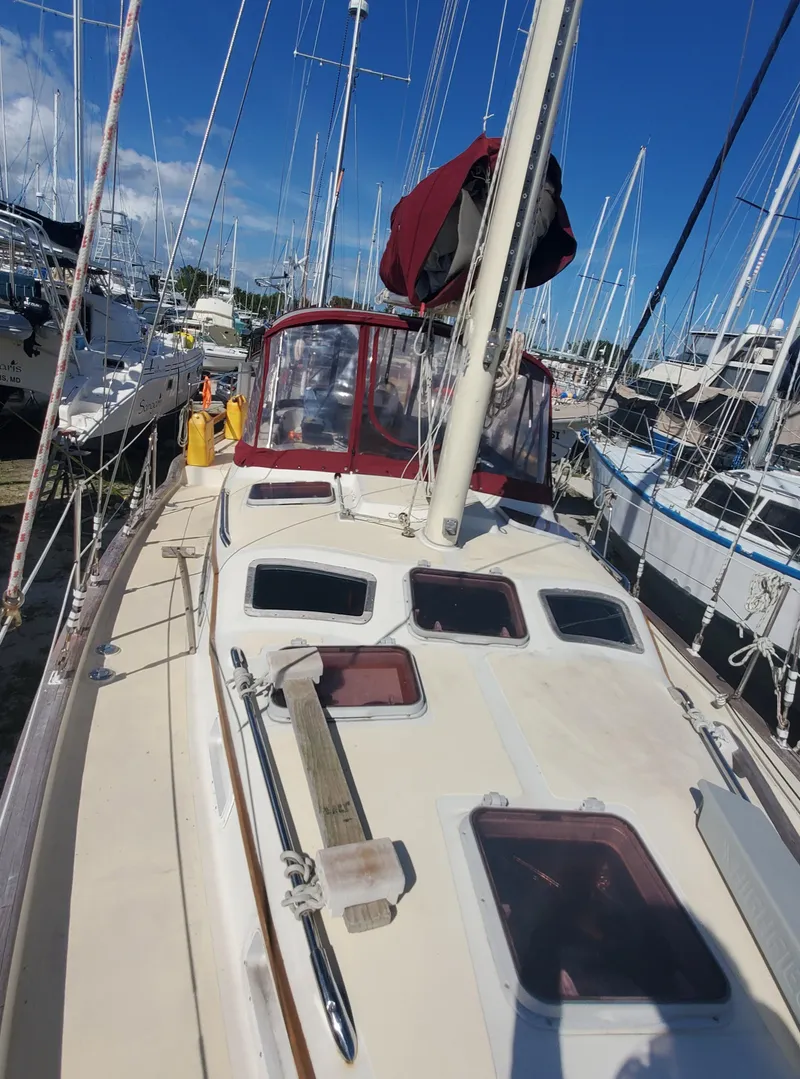 Slide: The Image of 1987 Irwin MKII sailboat docked in a marina under a clear blue sky. - 9