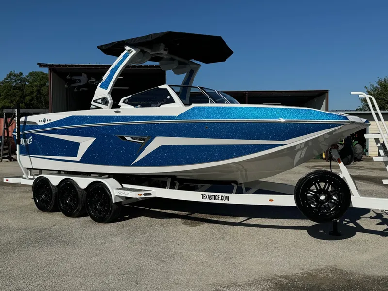 The Image of 2025 Tigé 24RZX boat with blue and white design on a trailer. - 0