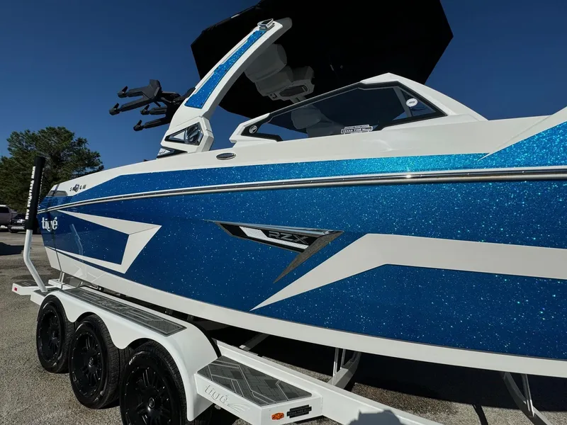 Slide: The Image of 2025 Tigé 24RZX boat with blue and white design on a trailer. - 4